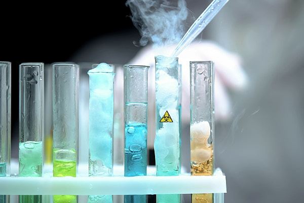 image of a scientist adding chemical to a test tube in a rack