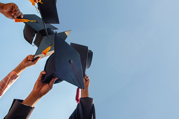 image of graduating students throwing caps in air